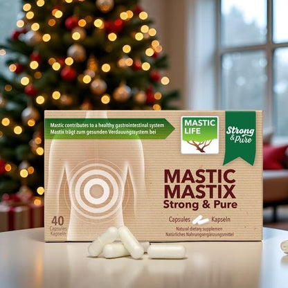 Box of Mastic Mastix Strong & Pure capsules with a Christmas tree in the background